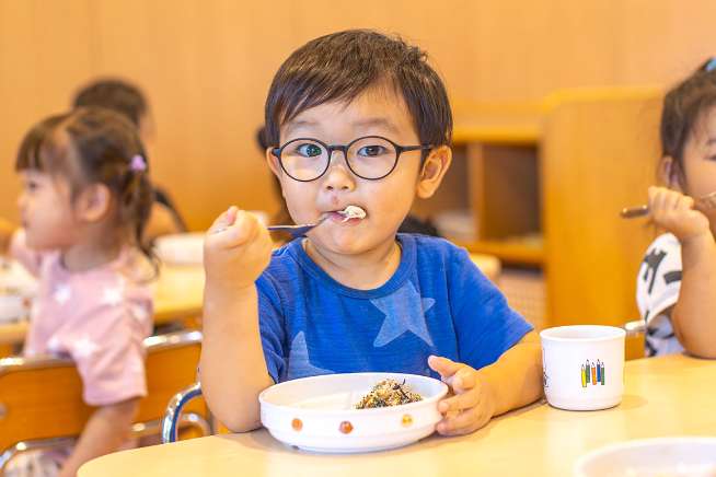 男の子が給食を食べている写真