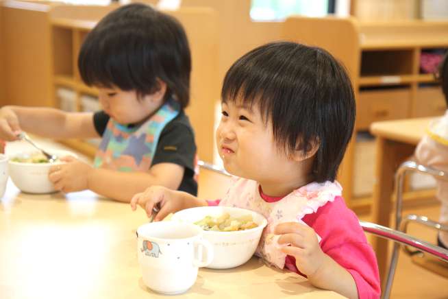 園児達がおいしそうに給食を食べている写真