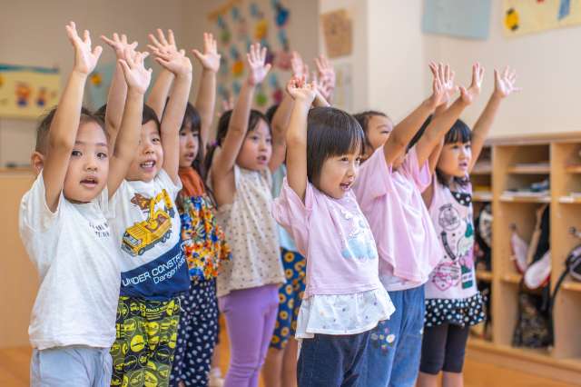 園児達が元気に両手をあげている様子